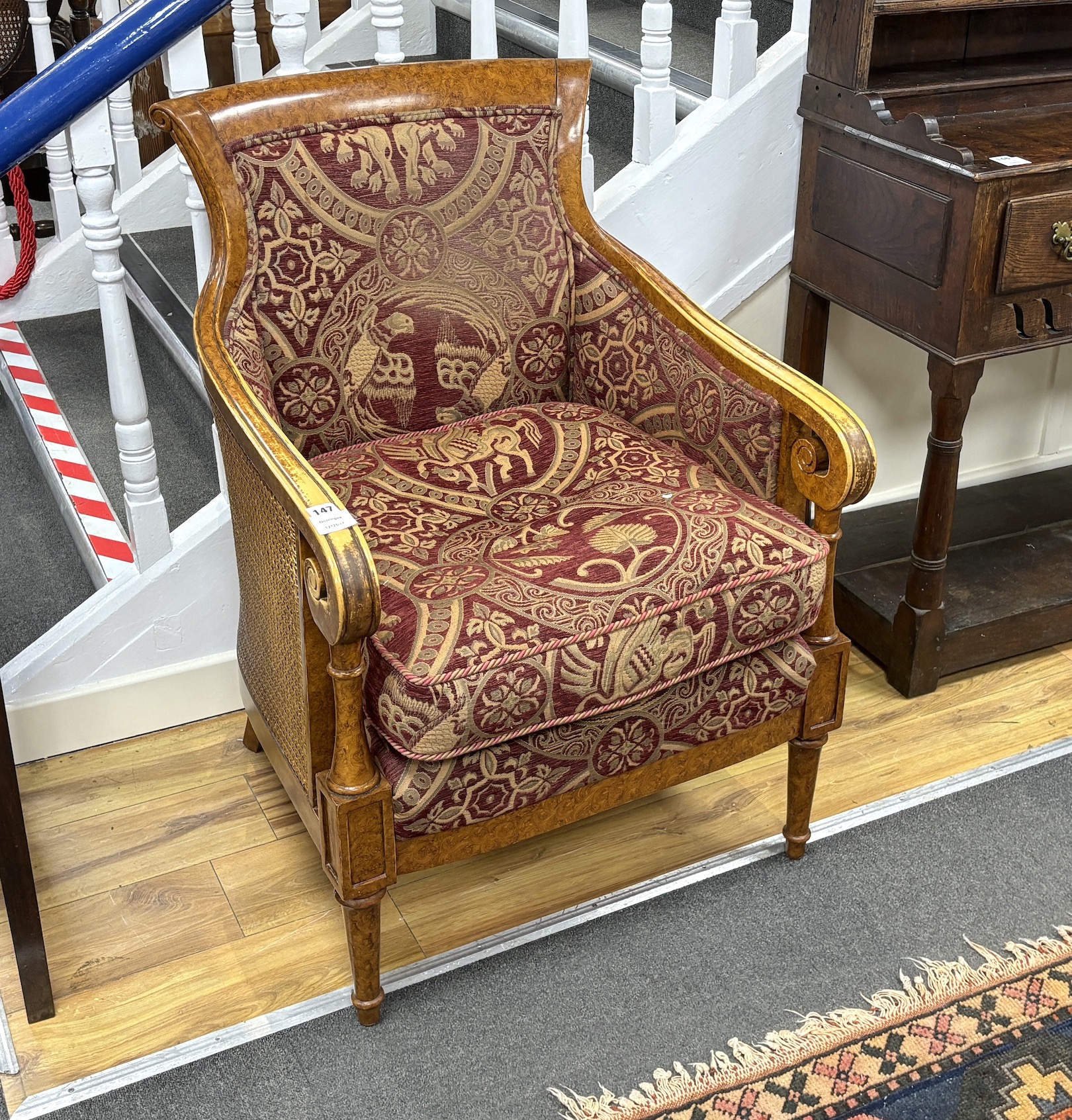 An Empire style bergère armchair, width 67cm, depth 62cm, height 95cm